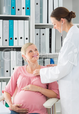 Doctor checking heartbeats of pregnant woman