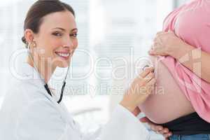 Portrait of doctor checking pregnant woman