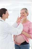 Doctor examining thyroid glands of pregnant woman