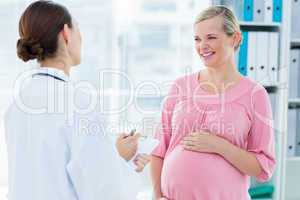 Pregnant woman discussing with female doctor
