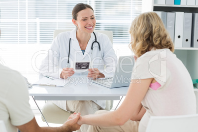 Gynaecologist talking to expectant couple