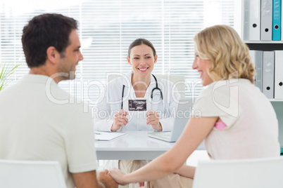 Gynaecologist looking at expectant couple