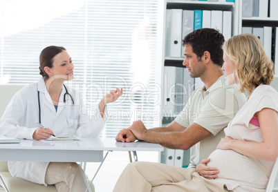 Dynaecologist discussing with expectant couple