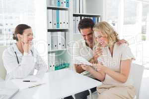Expectant couple looking at reports in clinic