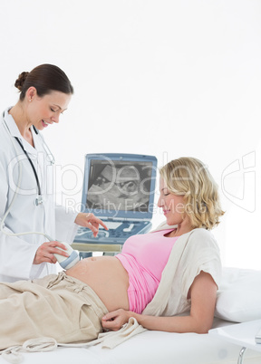 Doctor performing ultrasound on pregnant woman