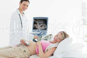 Doctor using ultrasound machine on pregnant woman