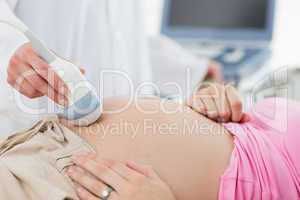 Doctor doing ultrasound on pregnant woman