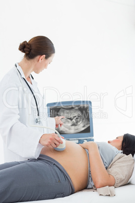 Doctor performing ultrasound on pregnant woman