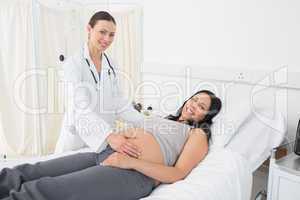 Confident female doctor with pregnant woman