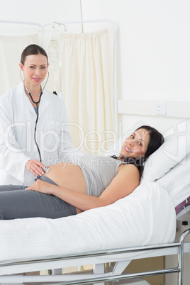 Confident doctor examining pregnant woman