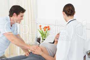 Doctor with happy expectant couple