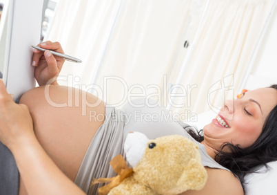 Pregnant woman writing on clipboard