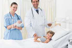 Doctors with sick girl in hospital ward