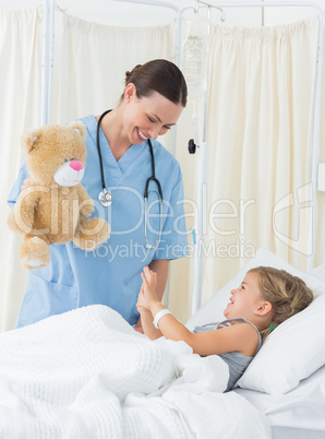 Playful doctor entertaining sick girl