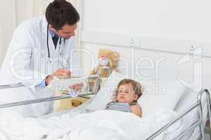 Doctor with clipboard attending ill girl