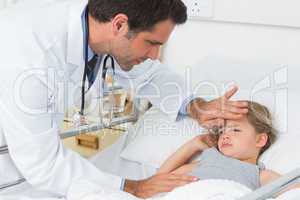 Doctor examining temperature of ill girl