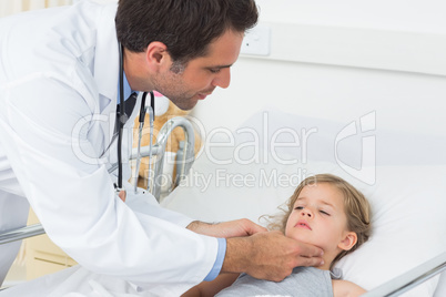 Doctor checking thyroid glands of sick girl