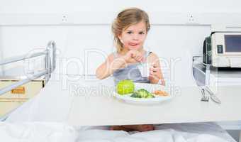 Sick girl eating healthy food in hospital