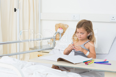 Girl coloring picture book in hospital