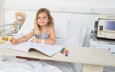 Portrait of girl coloring book in hospital