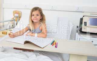 Portrait of girl coloring book in hospital