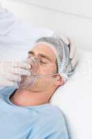 Doctor adjusting oxygen mask on male patient