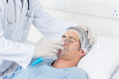 Doctor adjusting oxygen mask on patient