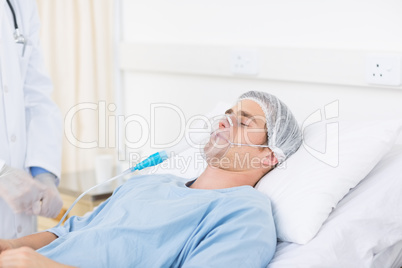 Male doctor adjusting oxygen mask on patient