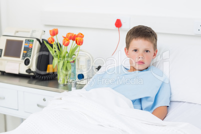 Boy reclining in hospital bed