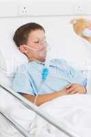 Boy with oxygen mask in hospital ward