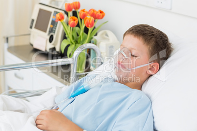 Boy wearing oxygen mask in hospital