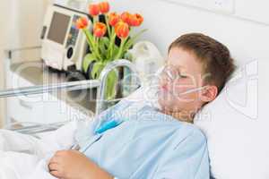 Boy wearing oxygen mask in hospital