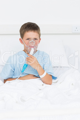 Boy on bed with oxygen mask in hospital