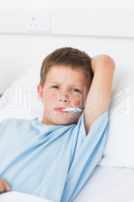 Boy with thermometer in mouth in ward