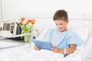 Boy using digital tablet in hospital