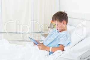 Little boy using digital tablet in hospital