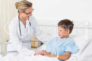 Doctor examining sick boy in hospital