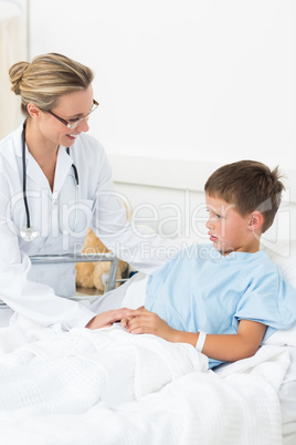 Doctor comforting sick boy in hospital
