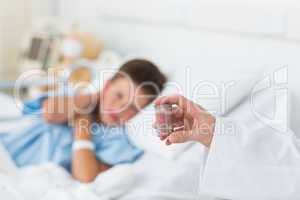 Doctor holding pill bottle with boy in hospital