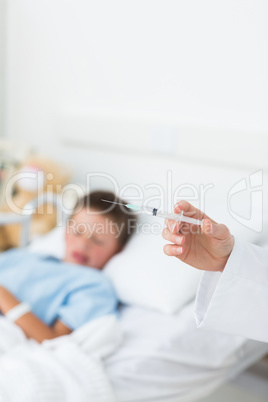 Doctor holding syringe with boy in hospital