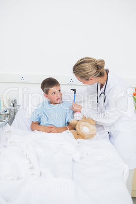 Doctor checking ears of boy