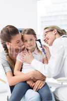 Girl being examined by pediatrician with otoscope