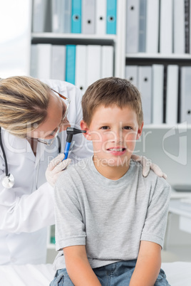 Boy being examined by pediatrician with otoscope