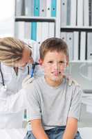 Boy being examined by pediatrician with otoscope