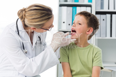 Doctor checking mouth of boy