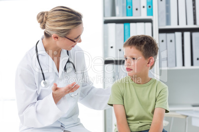 Doctor communicating with boy in clinic