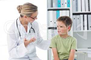 Doctor communicating with boy in clinic