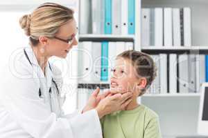 Pediatrician examining thyroid gland of boy