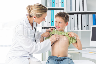 Doctor examining boy with stethoscope