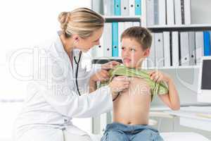 Doctor examining boy with stethoscope